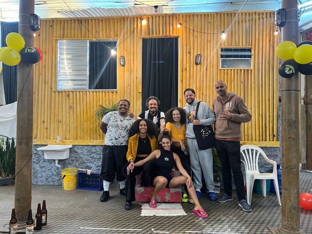 Filipe Celestino ao centro, de camisa do Corinthians, ao lado de Emicida e do elenco da peça “Tá Pra Vencer”