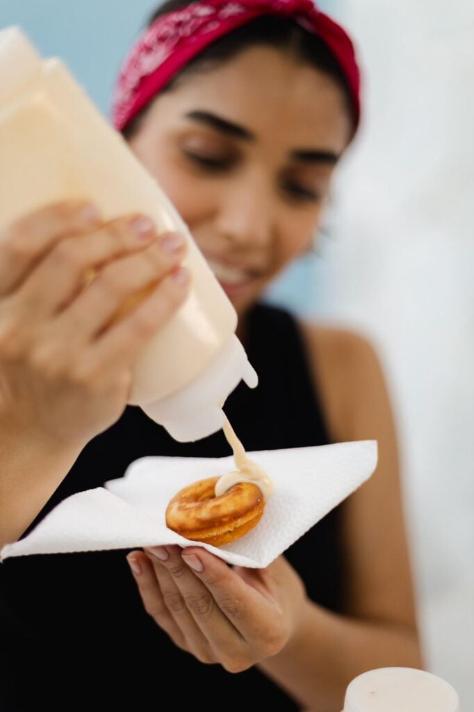 A empreendedora coloca recheio no donuts
