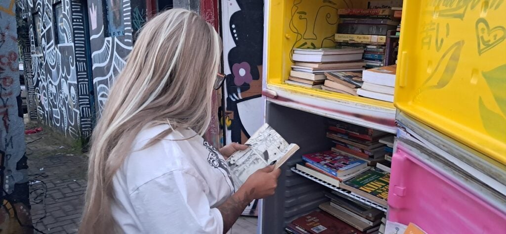 Moradora escolhendo um livro na geloteca