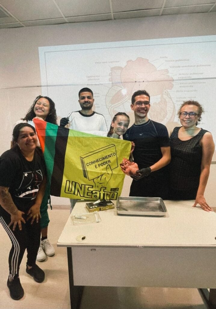 Henrique em uma aula de biologia no cursinho popular. Veruschka está segurando a bandeira do Mabel Assis